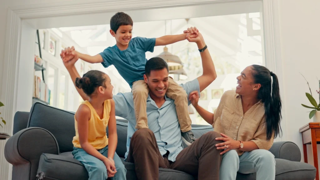 Parent and child playing actively together indoors, demonstrating screen-free bonding through movement