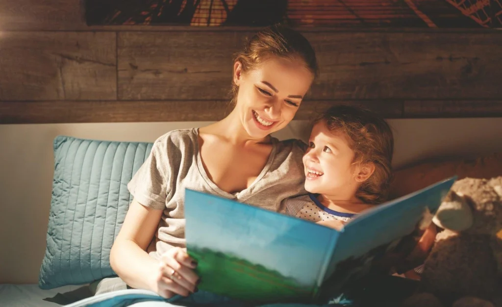 Parent and child cuddled together reading a book in soft natural light