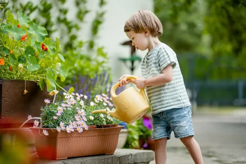 A young child watering a plant, symbolizing how love fuels emotional growth.