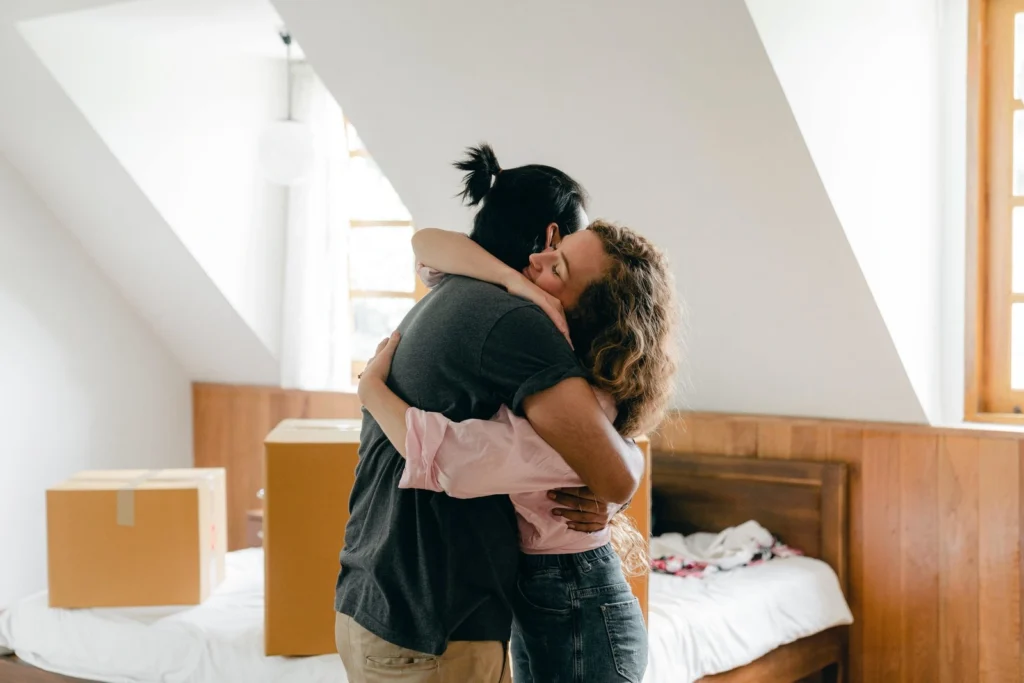 A couple sharing a long, comforting hug in their home, rebuilding physical connection.