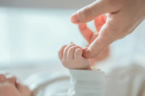 Close up detail of a parent holding a small child's hand