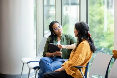 A woman tracking her cycle and symptoms in a notebook to monitor hormonal anxiety.
