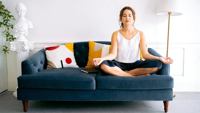 A mother sitting peacefully on the sofa after using a 5-minute mindfulness exercise to stop anxiety.