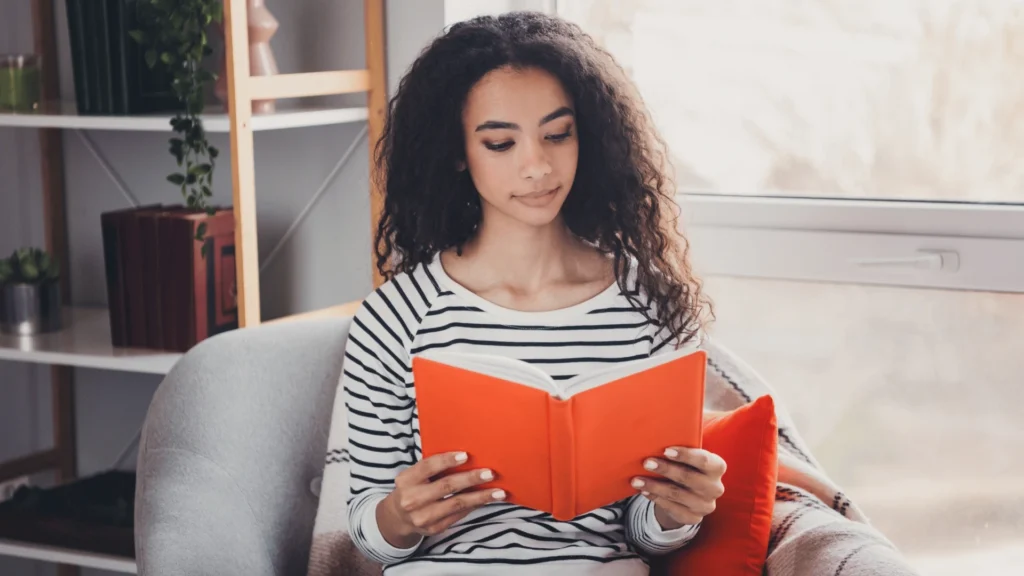 A woman relaxing with a book, enjoying free time after sharing the mental load