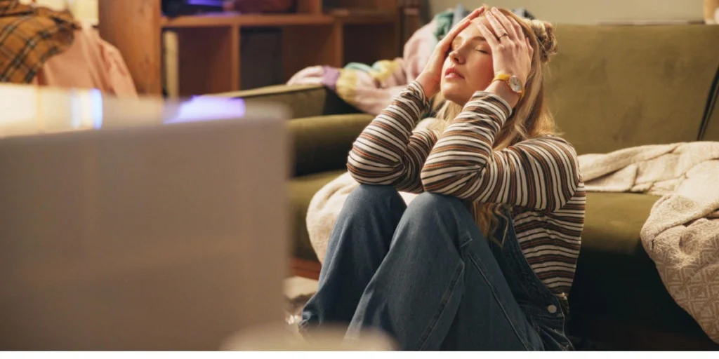 A tired parent sitting on the floor, representing how stress and cortisol can block connection.