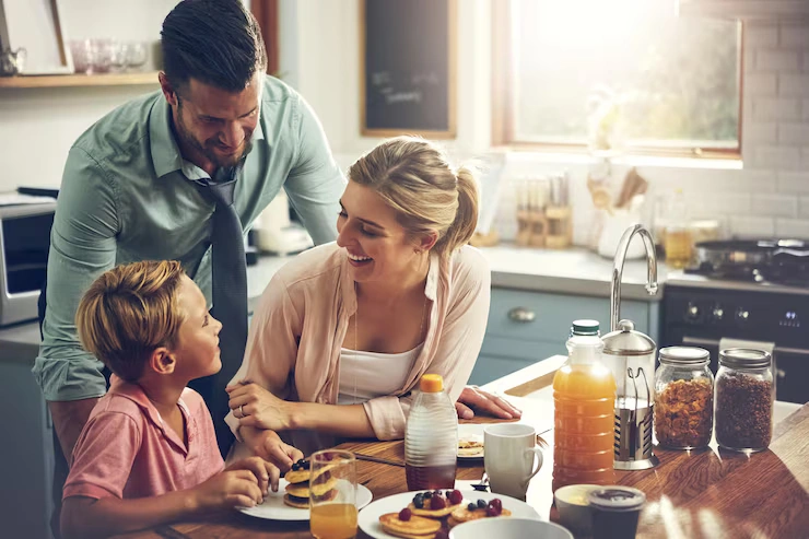 Parents standing together in a kitchen, sharing a moment of connection during a busy day with kids.