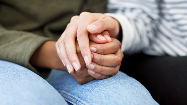 A close-up of a couple holding hands, symbolizing partnership and support through anxiety.