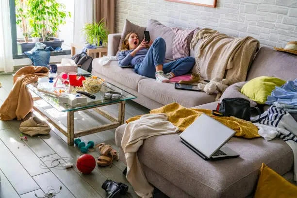 A realistic view of a messy living room with a tired parent, contrasting with curated social media feeds.