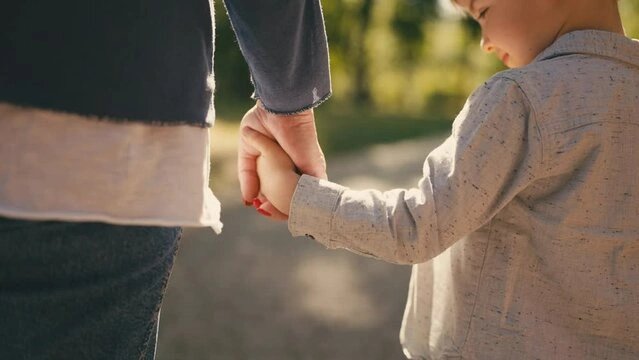 a parent holding the hand of kid