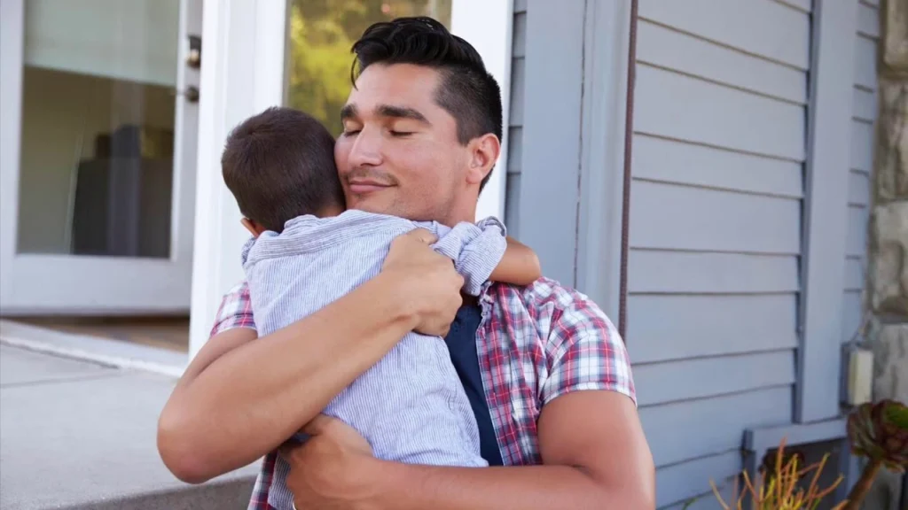 A father hugging his son to repair the relationship after a difficult moment.