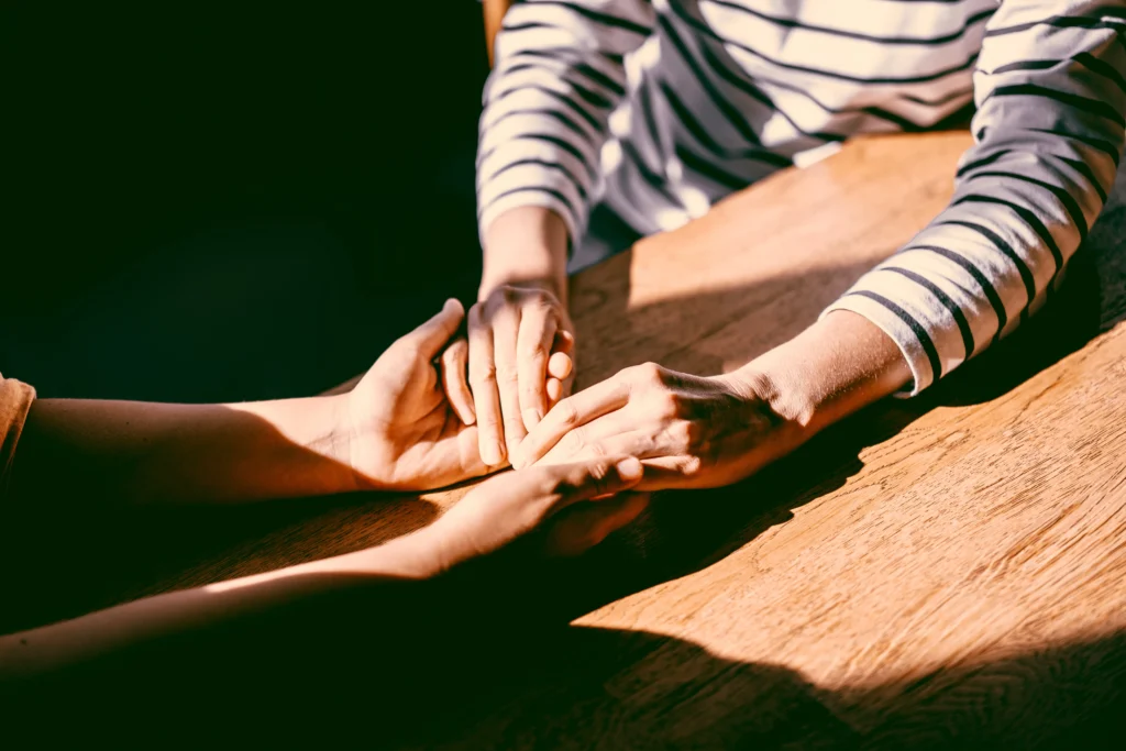 Close-up of a couple's hands gently holding each other, representing small moments of connection.
