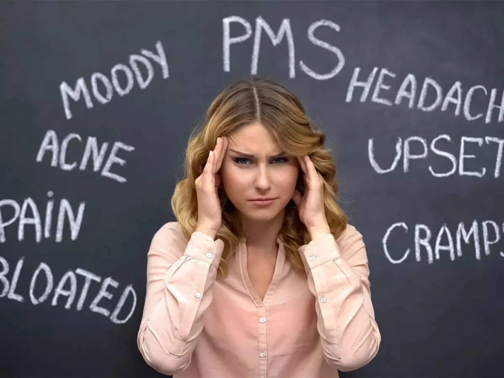A woman tracking her cycle and symptoms in a notebook to monitor hormonal anxiety.