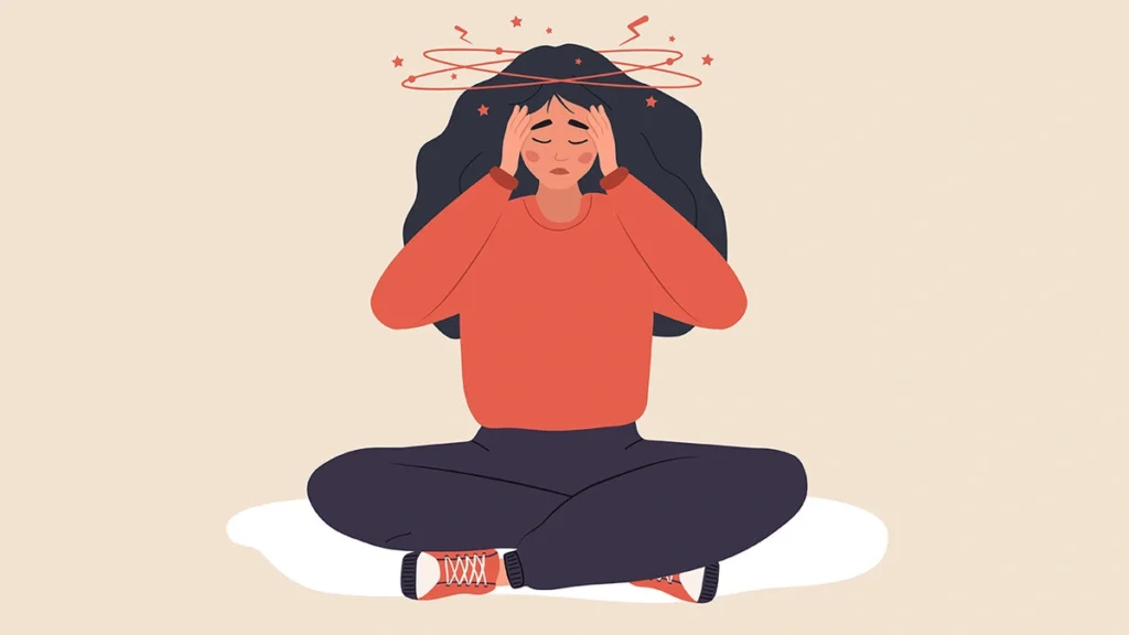 A person sits with their head in their hands, illustrating the overwhelming feeling of anxiety