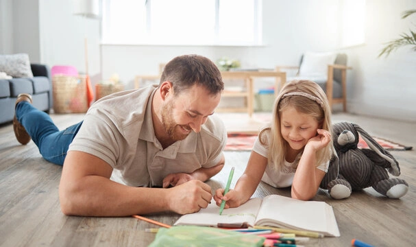 A parent and child looking closely at a drawing together, demonstrating a bid for connection.