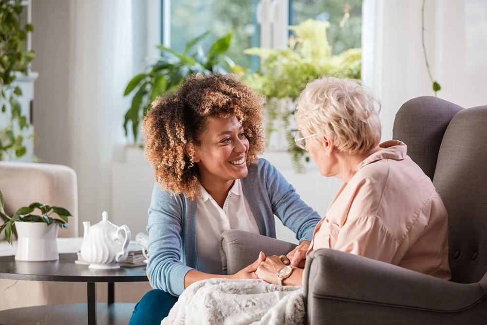 A caregiver crouching to eye level with a young child, demonstrating the calming connection that supports trauma recovery