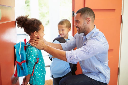 Parent and young child doing a special handshake goodbye ritual before school